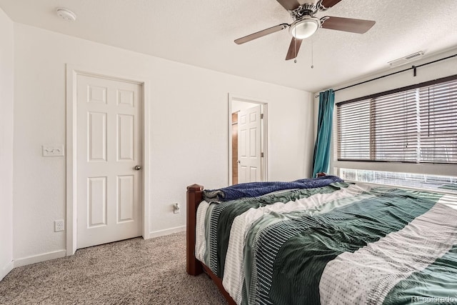 bedroom with ceiling fan, light carpet, and a textured ceiling