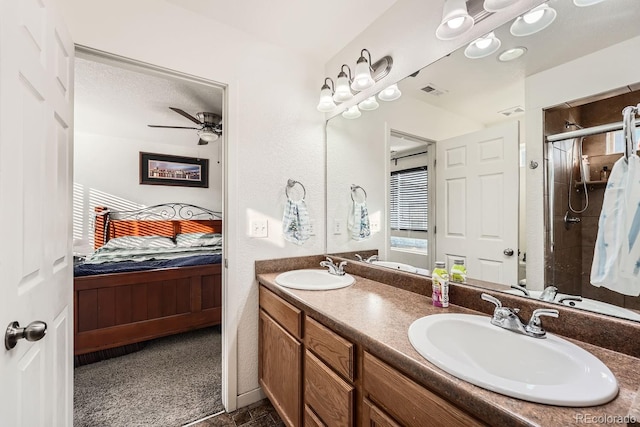 bathroom with vanity, ceiling fan, a shower with shower door, and a textured ceiling