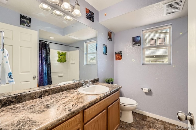 bathroom featuring walk in shower, vanity, toilet, and a wealth of natural light