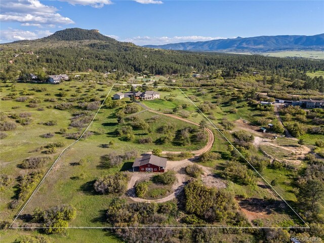3485 Park Ridge Rd, Sedalia, CO 80135 - aerial view of property's location featuring a mountainous background, property boundaries highlighted, and a heavily wooded area