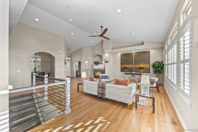 3485 Park Ridge Rd, Sedalia, CO 80135 - living room featuring wood finished floors, arched walkways, recessed lighting, ceiling fan, and a glass covered fireplace
