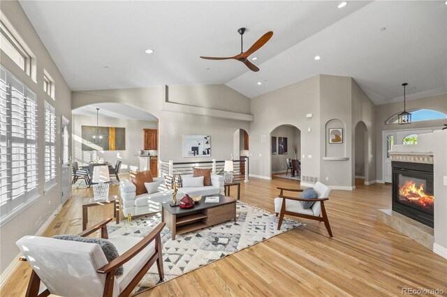3485 Park Ridge Rd, Sedalia, CO 80135 - living area with ceiling fan, high vaulted ceiling, arched walkways, light wood-style flooring, and baseboards