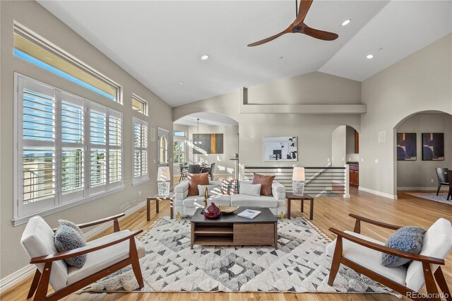 3485 Park Ridge Rd, Sedalia, CO 80135 - living room featuring arched walkways, ceiling fan, light wood finished floors, baseboards, and high vaulted ceiling