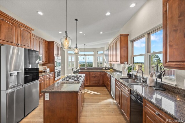 3485 Park Ridge Rd, Sedalia, CO 80135 - kitchen featuring appliances with stainless steel finishes, a sink, light wood-style floors, a center island, and dark stone counters