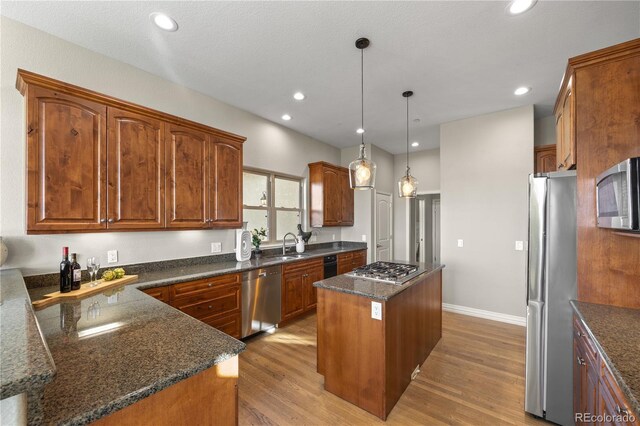 3485 Park Ridge Rd, Sedalia, CO 80135 - kitchen with stainless steel appliances, a kitchen island, light wood-style flooring, dark stone countertops, and recessed lighting
