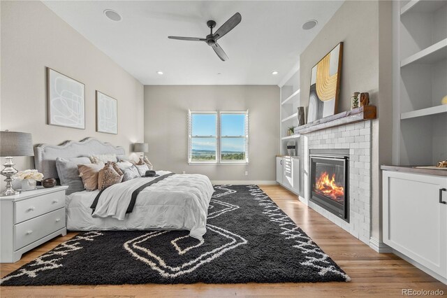 3485 Park Ridge Rd, Sedalia, CO 80135 - bedroom with light wood-style floors, a brick fireplace, baseboards, and a ceiling fan