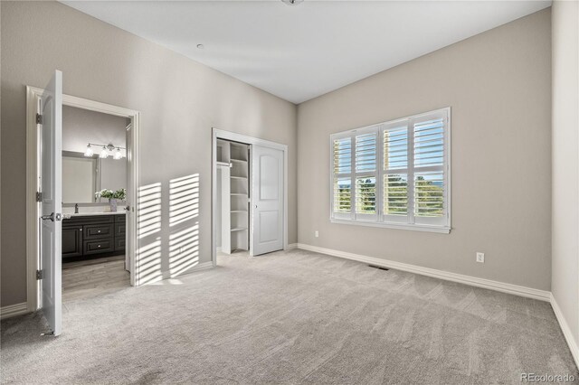 3485 Park Ridge Rd, Sedalia, CO 80135 - unfurnished bedroom with carpet flooring, baseboards, ensuite bathroom, a sink, and a closet