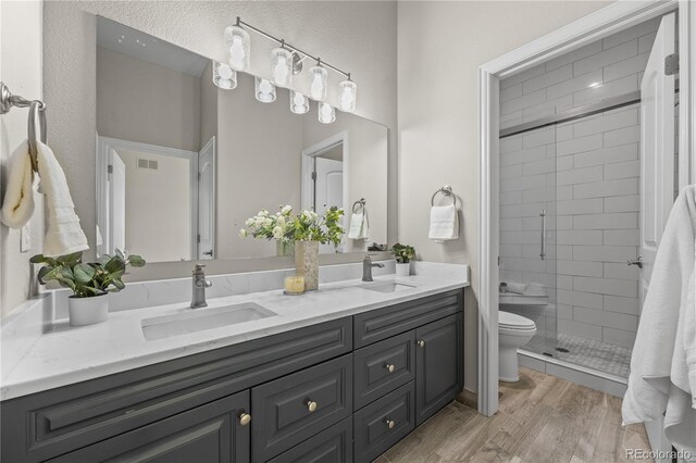 3485 Park Ridge Rd, Sedalia, CO 80135 - bathroom featuring toilet, double vanity, a shower stall, and wood finished floors