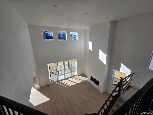 unfurnished living room featuring baseboards, a high ceiling, and wood finished floors