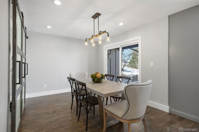 dining area featuring a barn door and dark hardwood / wood-style floors