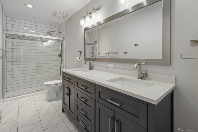 bathroom featuring a shower with door, vanity, and toilet