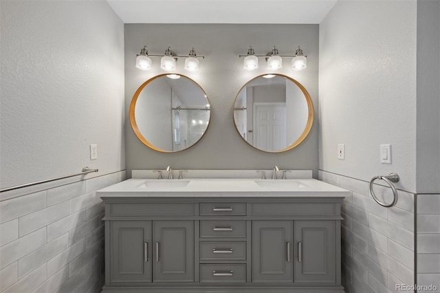 bathroom with vanity and tile walls