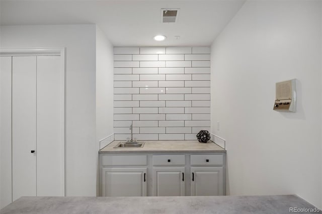 interior space with white cabinetry, sink, and decorative backsplash