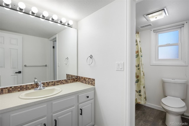 bathroom featuring toilet, wood-type flooring, a textured ceiling, vanity, and decorative backsplash