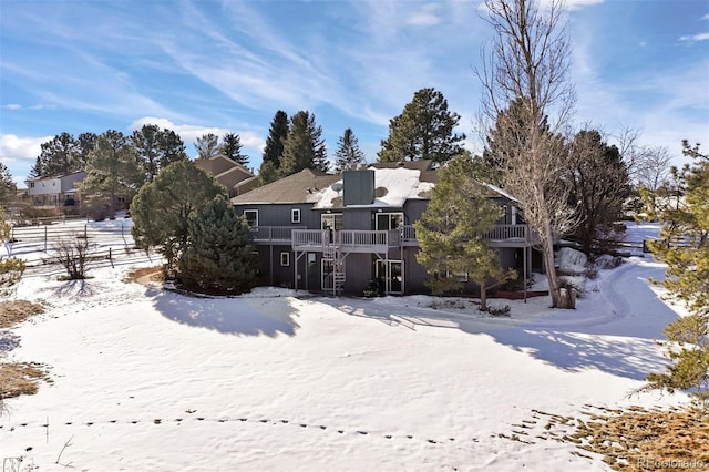 view of snow covered back of property