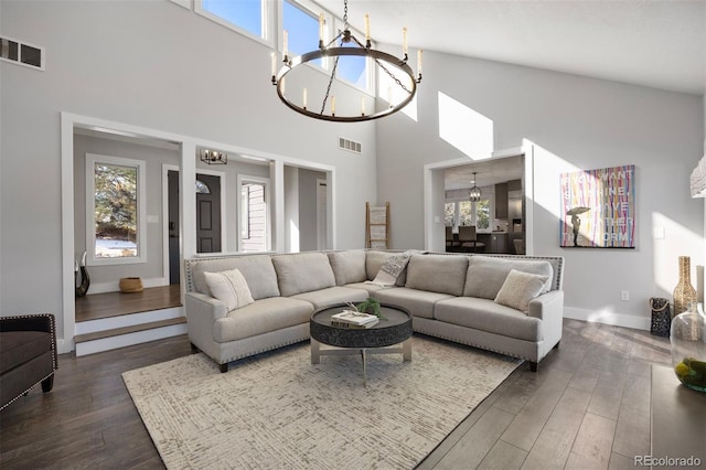 living room featuring dark hardwood / wood-style floors, a chandelier, and a high ceiling