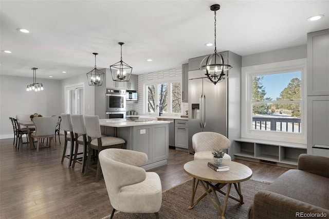 kitchen with a center island, light countertops, a notable chandelier, gray cabinetry, and stainless steel appliances