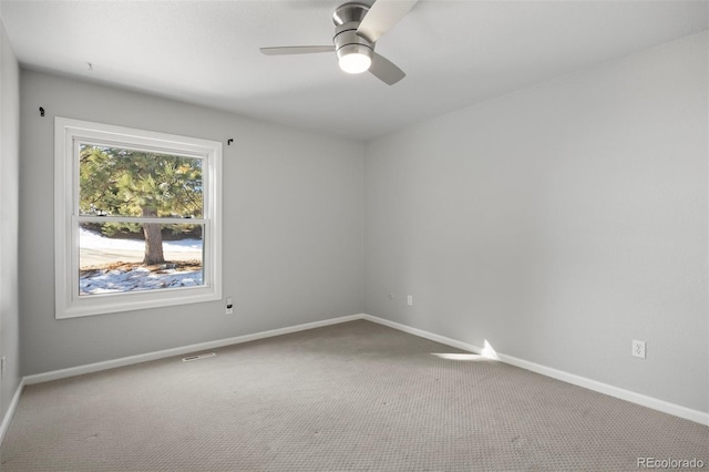 carpeted empty room featuring baseboards, ceiling fan, and visible vents
