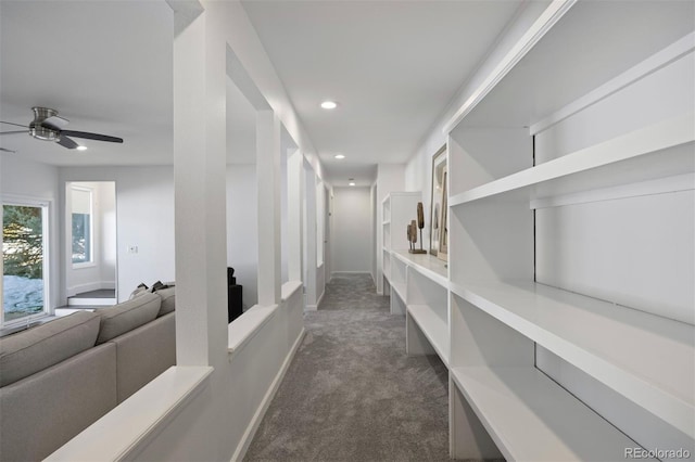 hall featuring recessed lighting, baseboards, and dark carpet