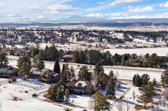 snowy aerial view featuring a residential view and a mountain view