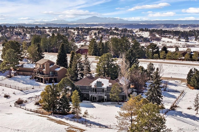 snowy aerial view featuring a residential view and a mountain view
