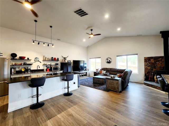 45 Saltlick Cir, Florissant, CO 80816 - kitchen with dark countertops, a ceiling fan, a breakfast bar area, stainless steel appliances, and visible vents
