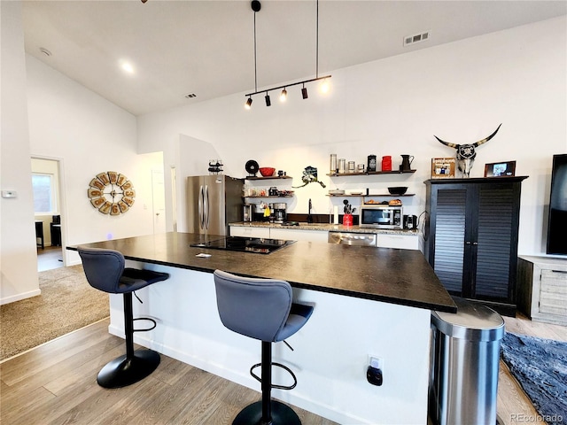 45 Saltlick Cir, Florissant, CO 80816 - bar with light wood finished floors, stainless steel appliances, vaulted ceiling, visible vents, and hanging light fixtures