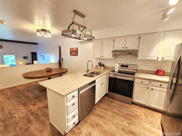 154 Fawn Ct, Silverthorne, CO 80443 - kitchen with appliances with stainless steel finishes, a sink, a peninsula, tasteful backsplash, and a textured ceiling
