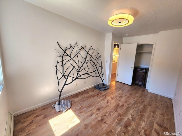 154 Fawn Ct, Silverthorne, CO 80443 - unfurnished bedroom with baseboard heating, wood finished floors, baseboards, and a closet