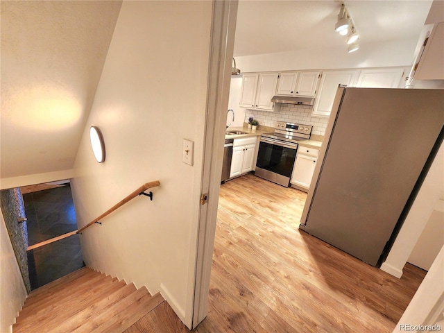 154 Fawn Ct, Silverthorne, CO 80443 - kitchen featuring appliances with stainless steel finishes, under cabinet range hood, light wood finished floors, white cabinetry, and light countertops