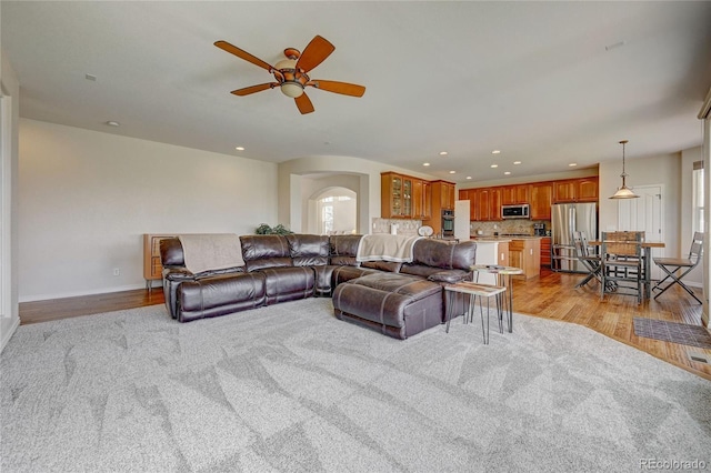 living room with ceiling fan and light hardwood / wood-style flooring