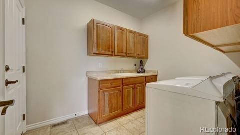 laundry room with cabinets, washer / clothes dryer, and sink