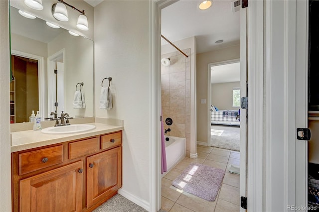 bathroom with tile patterned flooring, vanity, and tiled shower / bath