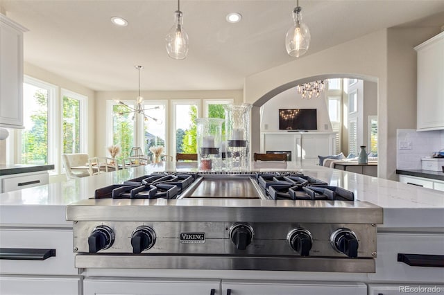 618 Fairchild Dr, Highlands Ranch, CO 80126 - kitchen with stainless steel gas stovetop, plenty of natural light, arched walkways, and a chandelier