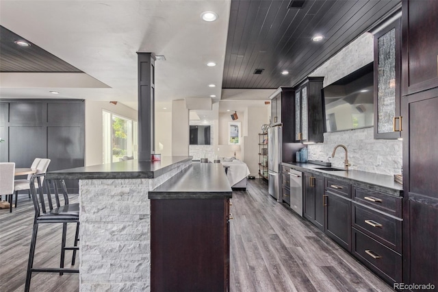 618 Fairchild Dr, Highlands Ranch, CO 80126 - kitchen with dark countertops, a kitchen bar, dark wood-style floors, and a sink