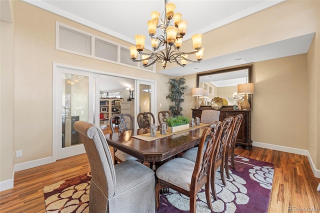 dining space featuring hardwood / wood-style flooring and an inviting chandelier