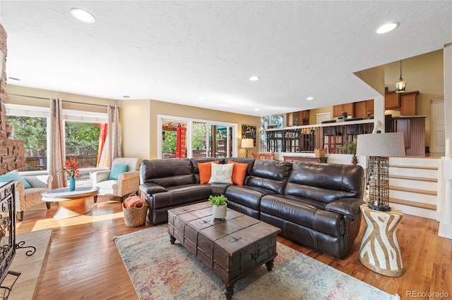 living room featuring a textured ceiling and light wood-type flooring