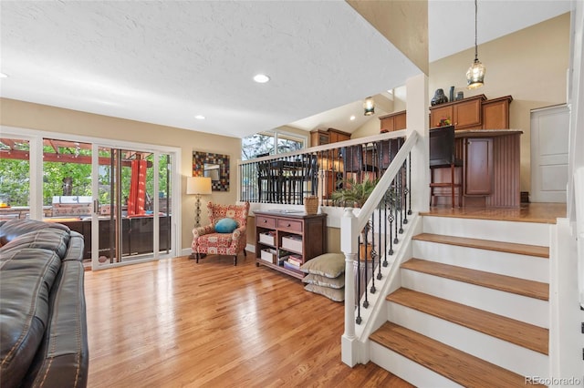 interior space featuring hardwood / wood-style floors, vaulted ceiling, and a textured ceiling