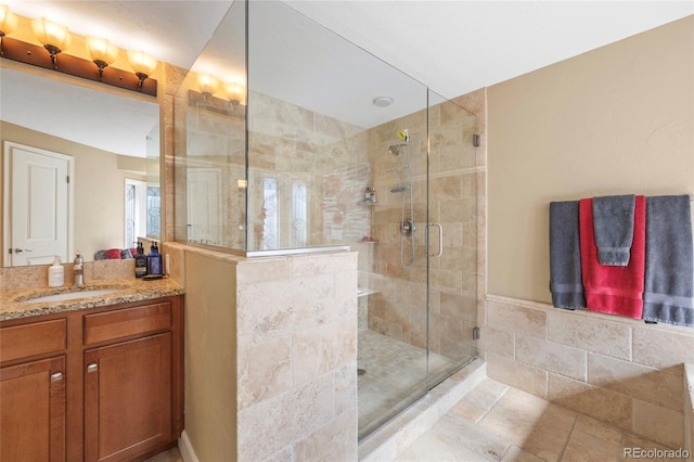 bathroom featuring tile patterned floors, walk in shower, and vanity