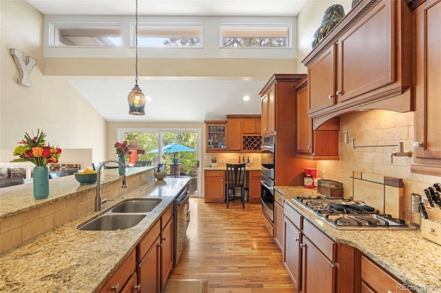 kitchen featuring appliances with stainless steel finishes, decorative light fixtures, sink, and decorative backsplash