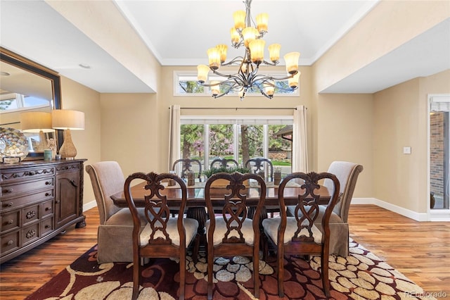 dining area with ornamental molding, hardwood / wood-style floors, and a chandelier