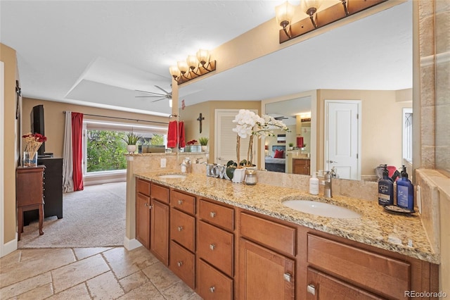 bathroom featuring vanity, ceiling fan, and a tray ceiling