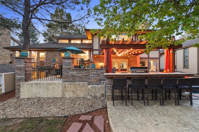 view of patio with exterior bar and a pergola