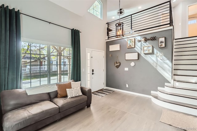 3805 E 106th Ave, Thornton, CO 80233 - living area with baseboards, stairway, a high ceiling, and wood finished floors