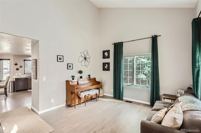 3805 E 106th Ave, Thornton, CO 80233 - sitting room featuring light wood-type flooring, baseboards, a healthy amount of sunlight, and a high ceiling
