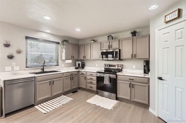 3805 E 106th Ave, Thornton, CO 80233 - kitchen with a sink, appliances with stainless steel finishes, gray cabinets, light wood-style floors, and recessed lighting