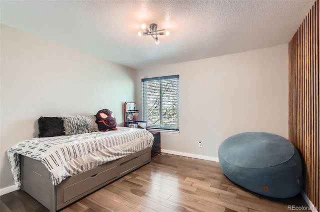 3805 E 106th Ave, Thornton, CO 80233 - bedroom featuring a textured ceiling, wood finished floors, and baseboards