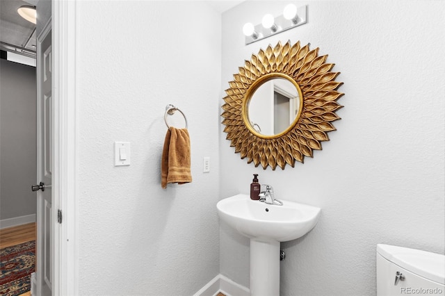 bathroom featuring hardwood / wood-style floors and toilet