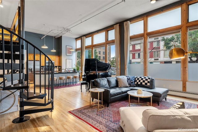 living room with hardwood / wood-style floors, a wealth of natural light, and a baseboard heating unit