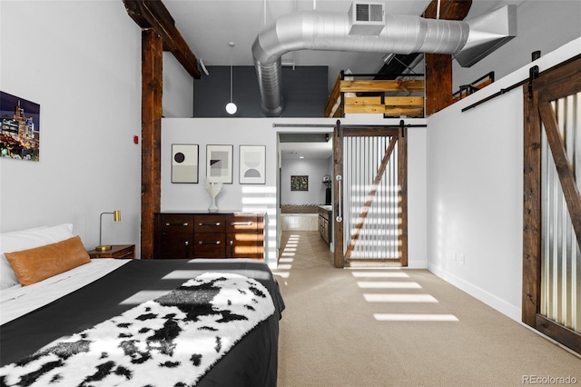 carpeted bedroom with a barn door and a towering ceiling